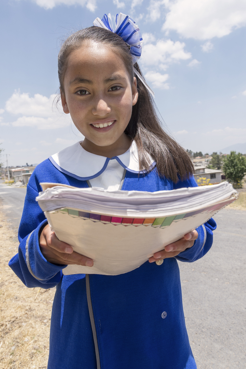 Very proud Mexican young student showing her good grades received in her homework.